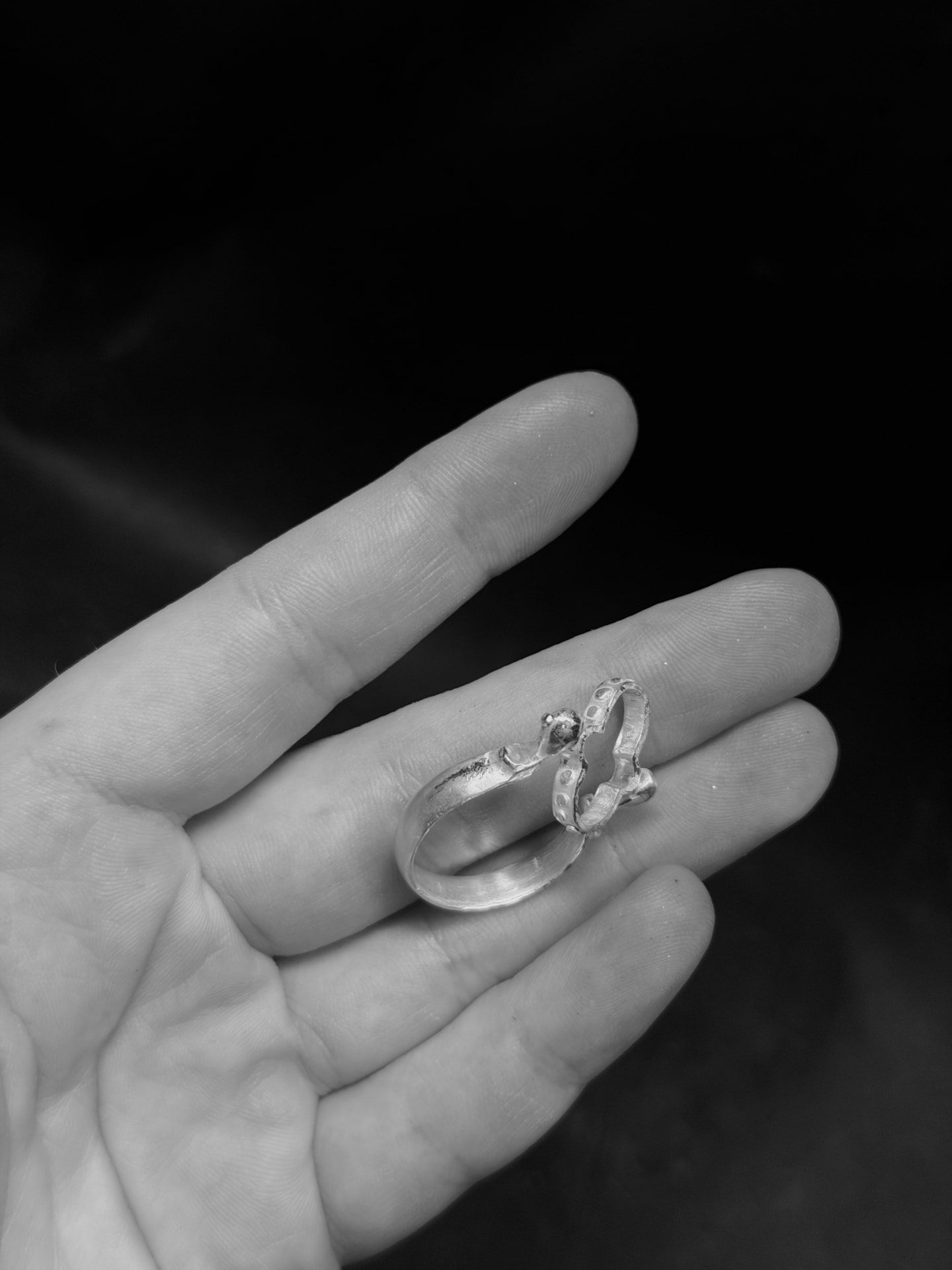 Back view of the reversible silver ring with labradorite resting in a palm, black and white